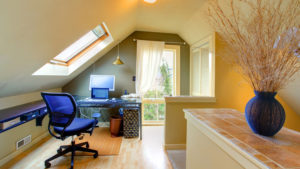 bright attic office with a desk, chair, and skylight