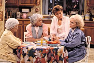 four women talking and sitting around a kitchen table
